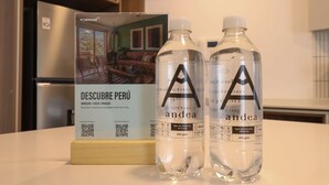 A brochure titled 'DESCUBRE PERÚ' and two bottles labeled 'andea sin gas' on a table. - w Exceptional 2BR With Balcony in San Isidro (Lima)