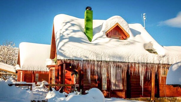 A log cabin with a snow-covered roof and icicles hanging from the eaves. - Kedra Village Superior Chalet - Mountain Escape (Makrakomi)