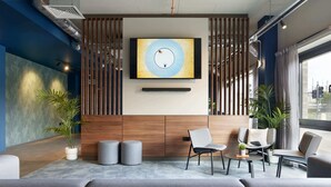En moderne reception med stort fjernsyn, siddepladser og planter.