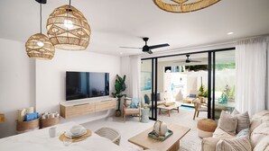 A modern living room with a flat-screen TV, wicker pendant lights, a ceiling fan, and a view of the outdoors through large windows. - Sorrento 15 2 Bedroom Townhouse (Gibbes)