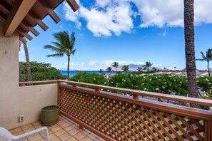 A balcony with a view of the ocean and palm trees. - Maui Kamaole, #h-208 2 Bedroom Condo (Kihei)