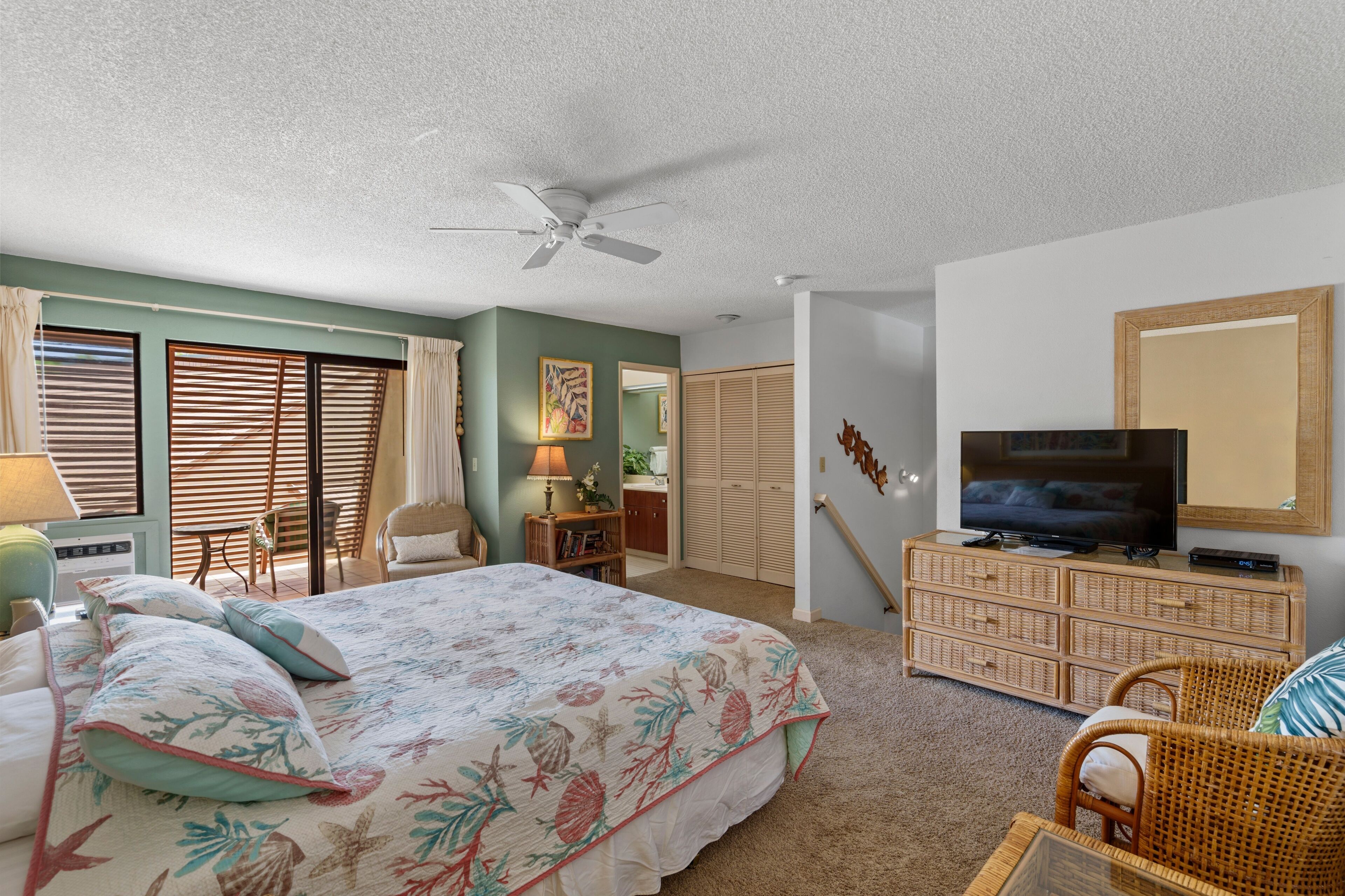 A bedroom with a bed, a television, a desk, and a chair.