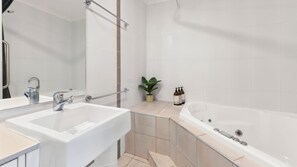 A modern bathroom with two sinks, a large bathtub, and a potted plant. - Pacifico Flynn s beach 319 (Port Macquarie)