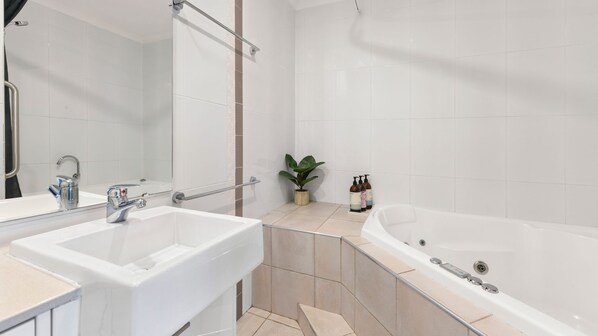 A modern bathroom with two sinks, a large bathtub, and a potted plant. - Pacifico Flynn s beach 319 (Port Macquarie)