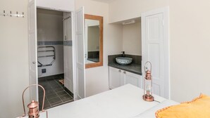 A bathroom with a shower, a sink with a vessel basin, and a mirror above the sink. - Ty'r Ddraig (Dartmouth)