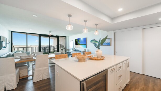 A spacious kitchen with a large island, white cabinetry, and a view to the outside. - Private Balcony With Unforgettable Waterfront Views (Port Aransas)