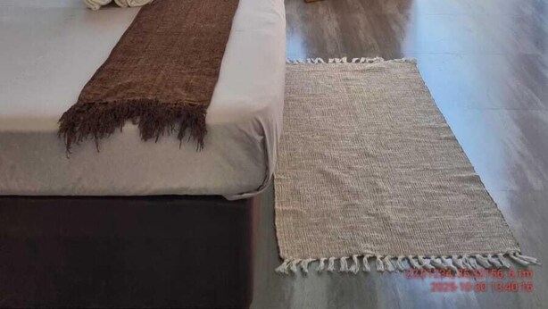 Ein modernes Schlafzimmer mit einem großen Bett, einer Hängeleuchte und Gartenblick durch eine Schiebetür.