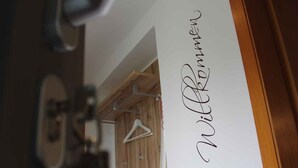 A wooden wall with a whiteboard and a white hanger. - Schrichten Apartment on the Edge of the Forest (Schmallenberg)