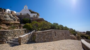 A stone staircase leading up to a white building with a bell tower, surrounded by greenery and a clear blue sky. - Scorpios Dream By Bestofmikonos Country House with Private Pool, Wi-Fi & Air Conditioning (Mykonos)