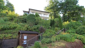 Un quartier résidentiel situé sur une colline, avec une cabane en bois et un immeuble à deux étages.