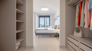 Un dormitorio con cama, armario y vistas a través de una puerta.