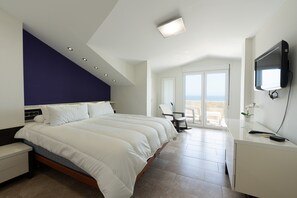 Une chambre moderne avec un grand lit, un bureau et une télévision.