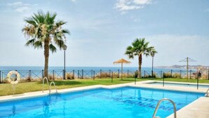 Una piscina con vista diretta sul mare e una recinzione.