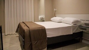 A hotel room with a bed, a bedside table, a mirror, and a curtain. - HOTEL BUSINESS (Casoria)