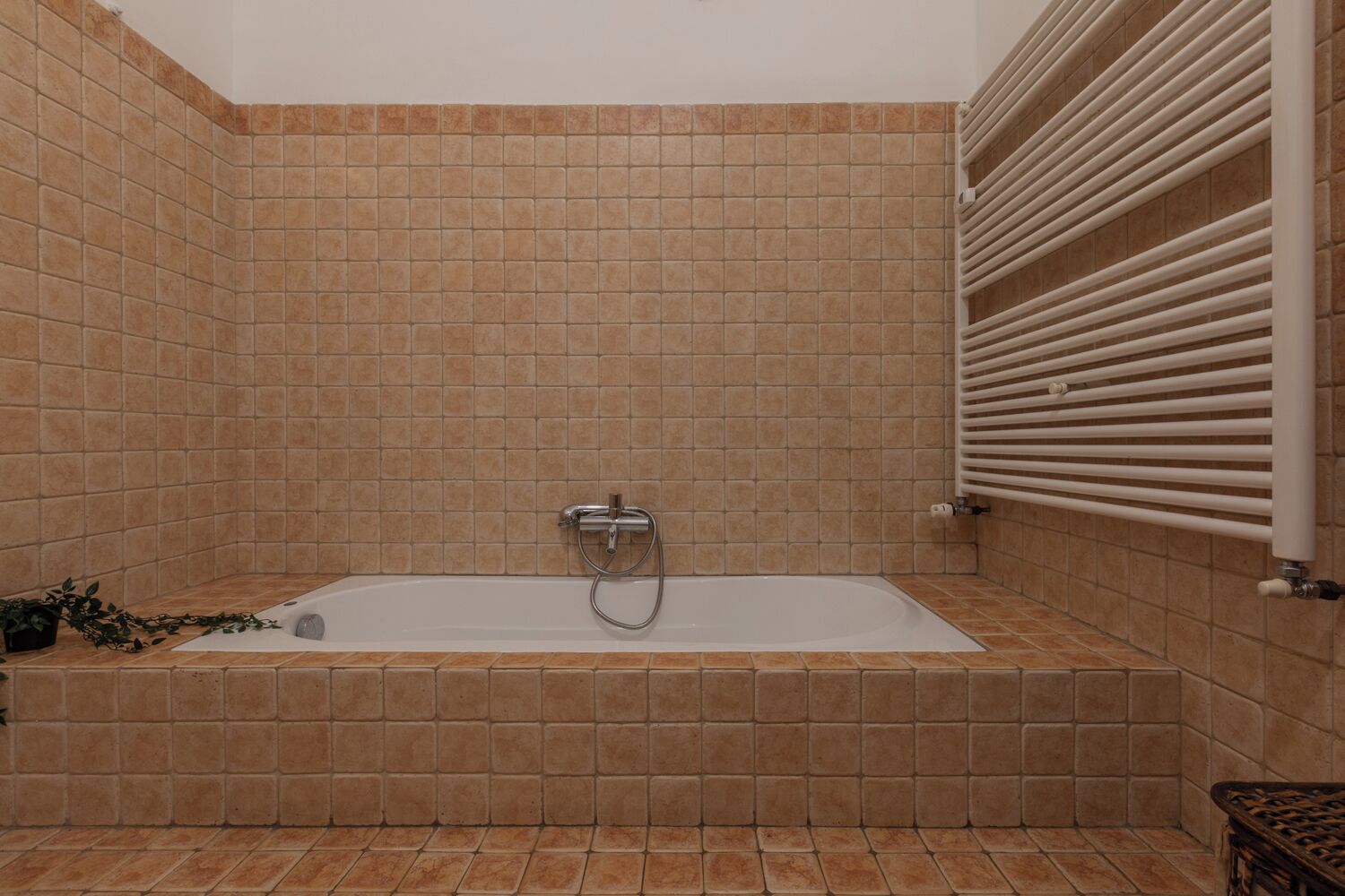 A bathroom with a bathtub, tiled walls, and a towel rack.