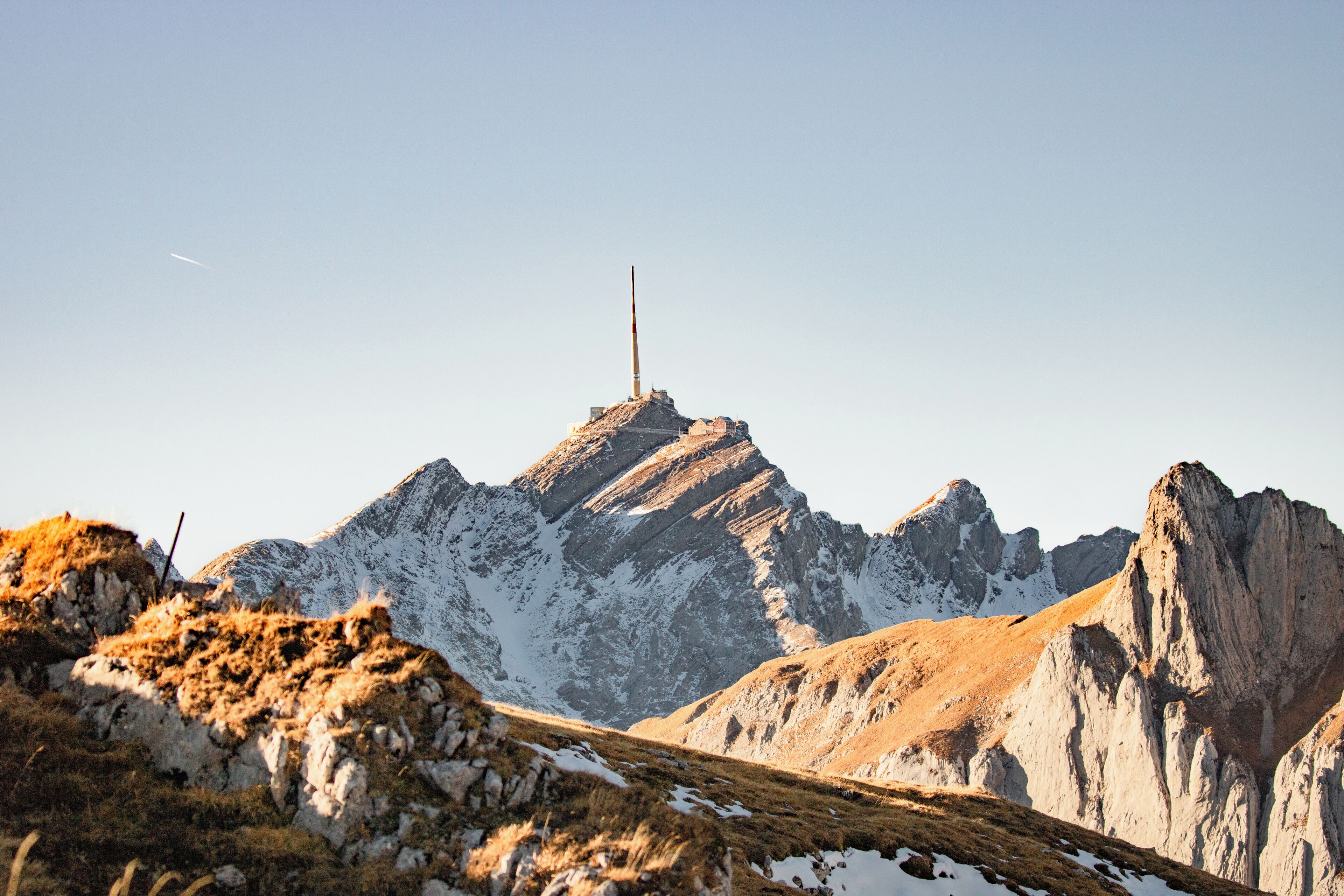 A mountain landscape with a prominent peak and a flagpole.