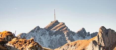 A mountain landscape with a prominent peak and a flagpole.