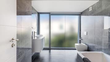Un baño moderno con bañera, inodoro y lavamanos, que cuenta con ventanas amplias y vistas a zonas verdes.