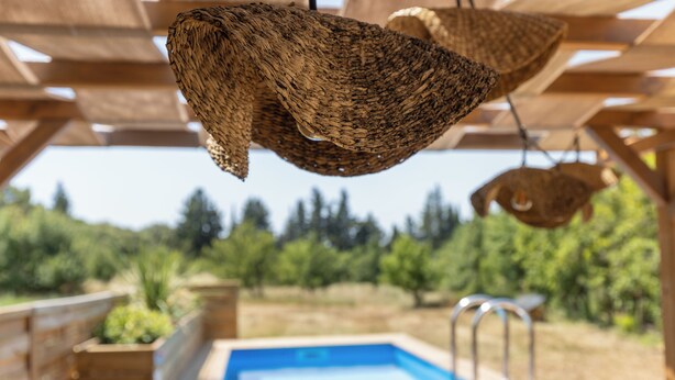 A wooden pergola with hanging woven baskets and a pool area. - Mas9Romanin:Gîte Evasion in Provence (Saint-Rémy-de-Provence)