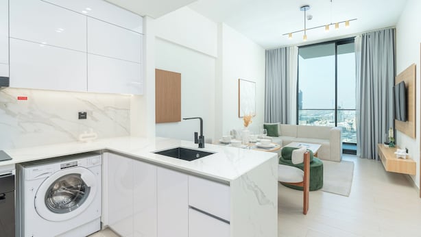 A modern apartment with a kitchen, a living area, and a balcony with a city view. - PVH - Cozy 1BR - Binghatti House (Dubai)