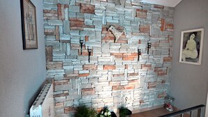 A stone wall with a modern design, a framed picture on the left, and a potted plant at the bottom. - Villa Buby by Villas Guide (Kraljevica)