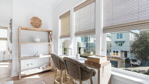 Eine moderne Küche mit einem Holzhocker, einer weißen Vase und einem Regal mit Dekorationen.