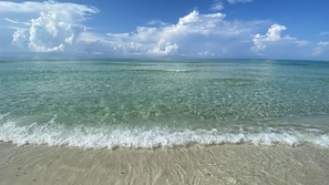 Una spiaggia con acque cristalline turchesi e onde calme.