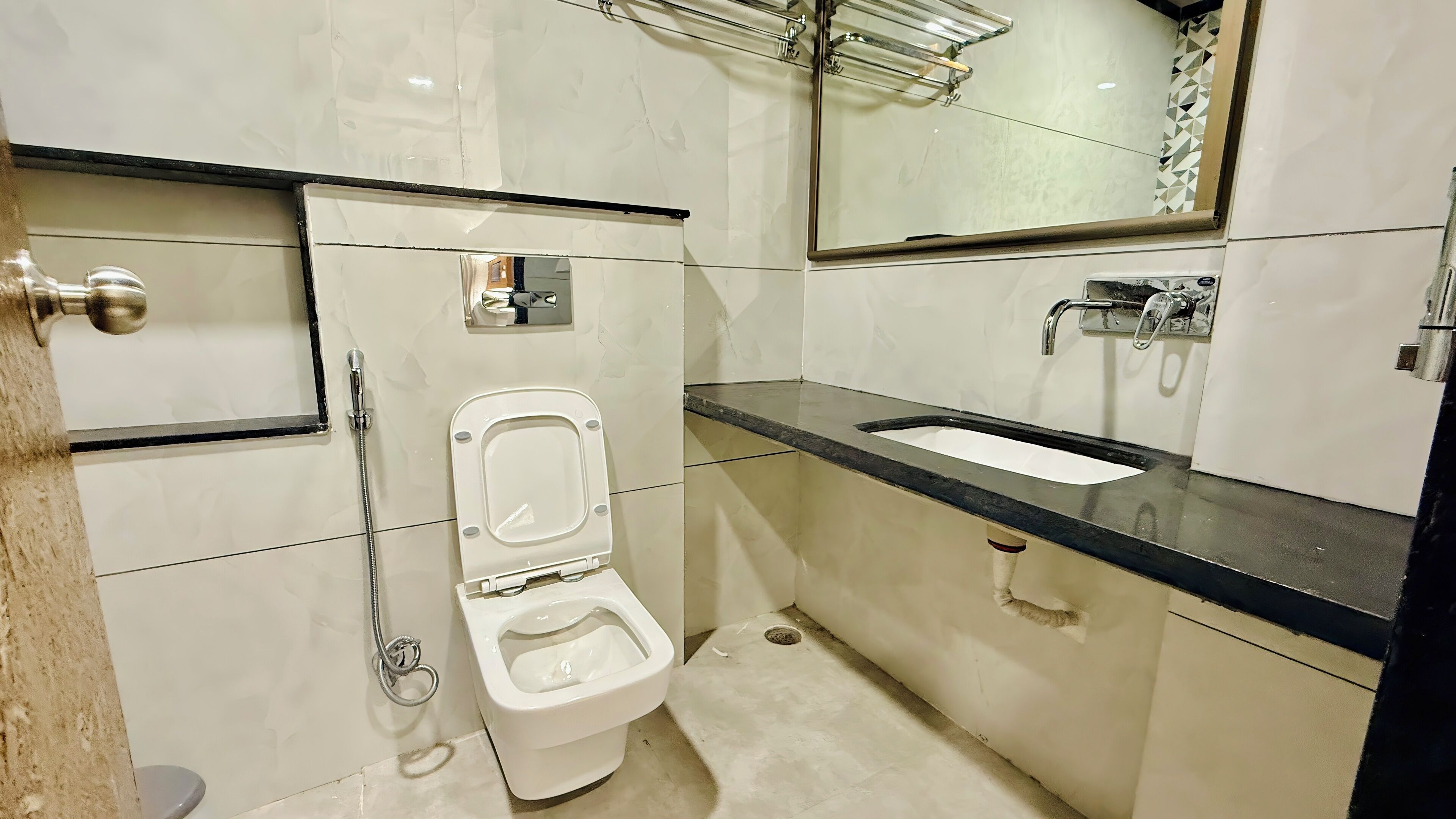 A compact bathroom with a toilet, sink, and mirror.