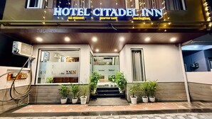 La façade de l’hôtel Citadel Inn, avec une enseigne indiquant la présence de chambres climatisées, d’un café sur le toit et d’un restaurant.