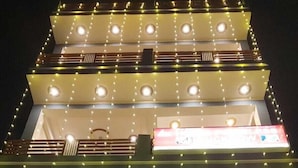 A hotel with multiple floors, balconies, and string lights. - HOTEL PRICELESS AMITY UNIVERSITY LUCKNOW (Lucknow)