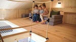 Un interior de madera con una escalera de cuerda, un sofá y una lámpara de lectura.