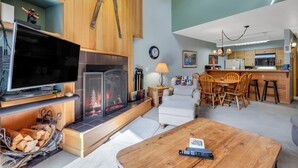 A modern living room with a fireplace, television, and dining area.