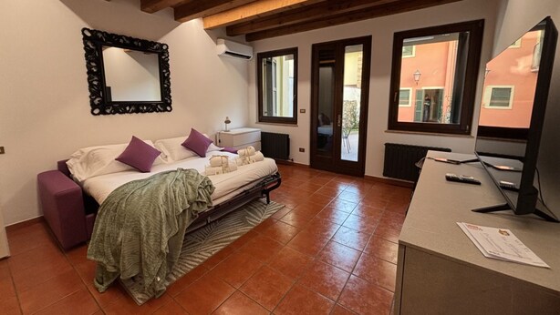 A bedroom with a bed, a desk, a mirror, and a window. - Veronetta 52 Garden - Verona Journeys (Verona)