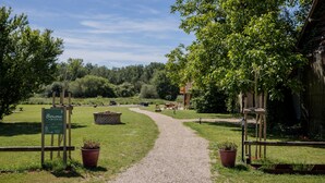 Un chemin de gravier mène à un bâtiment sur lequel on peut lire une enseigne indiquant « Burgersque » et « Accès & Cie. »
