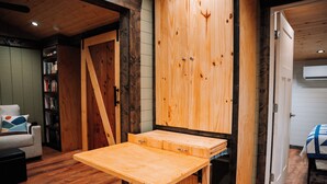 Une pièce avec une table en bois, une bibliothèque et une porte.