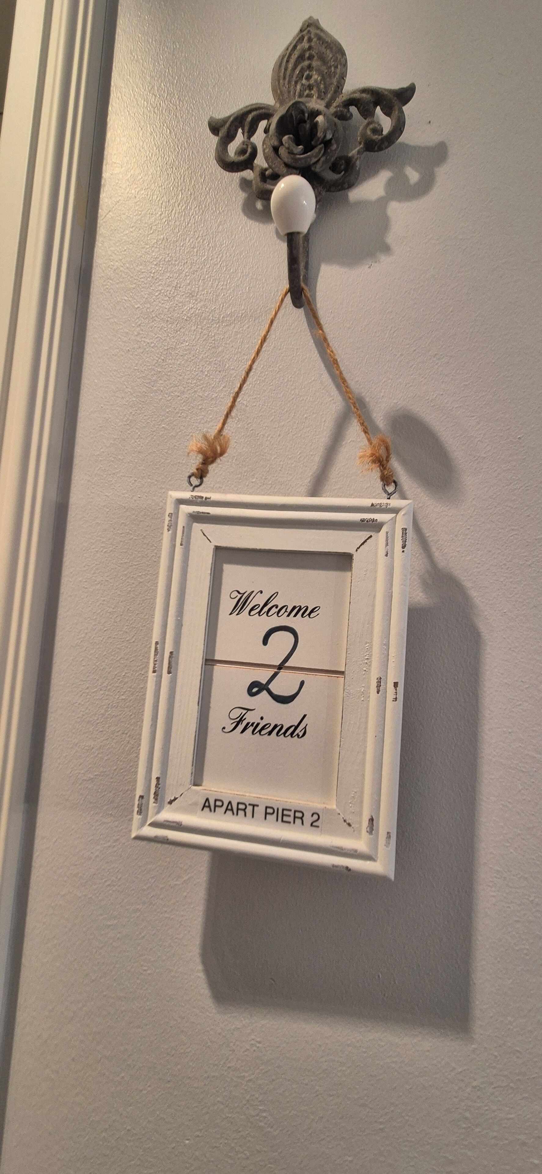 Une enseigne accueillante pour « Apartment Pier 2 », avec un élément décoratif fixé au mur juste au-dessus.