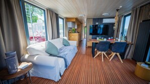 Una habitación moderna con sofá, mesa de comedor y televisor.