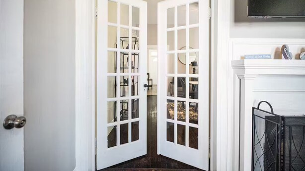 A white door with glass panels leading to a room with a fireplace and a sign that reads "Good Wishes Only". - Petersburg Vacation Gem 3BR - Private Backyard (Petersburg)