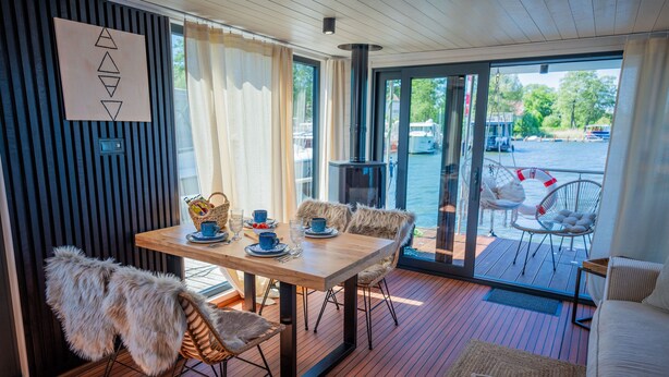Een modern interieur met een houten eettafel, stoelen en een bank.