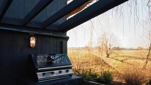 Una parrilla al aire libre con vistas a un campo y árboles.
