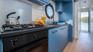 A modern kitchen with a gas stove, cabinets, and a view of the outdoors.