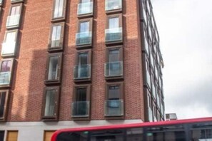 Un edificio de varios pisos con fachada de ladrillo y numerosas ventanas.