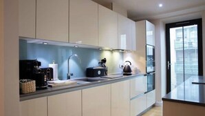 A modern kitchen with a built-in oven, a coffee maker, and a kettle. - Sunny Westminster 1-Bed with Terrace & AC – Walk to London’s Icons (London)