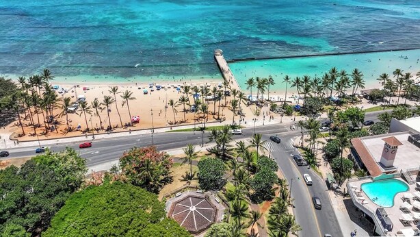 A beach resort with a swimming pool, palm trees, and a view of the ocean. - Chic Suite W/ Direct Ocean Views & Free Parking (Honolulu)