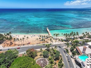 A beach resort with a swimming pool, palm trees, and a view of the ocean. - Chic Suite W/ Direct Ocean Views & Free Parking (Honolulu)