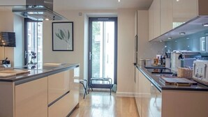 Una cocina moderna con una isla central, un comedor y vistas al exterior.