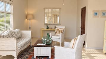 Una sala de estar con ventilador de techo, alfombra estampada y sofá blanco.