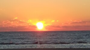 Een zonsondergang boven de oceaan met een heldere horizon.