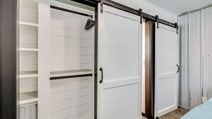 Una habitación con puerta corredera para el armario, estanterías empotradas y un radiador.