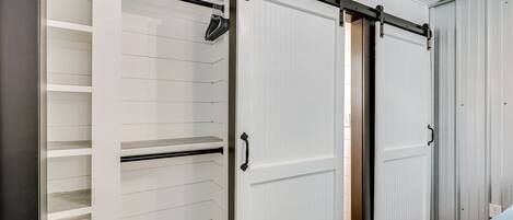 Una habitación con puerta corredera para el armario, estanterías empotradas y un radiador.
